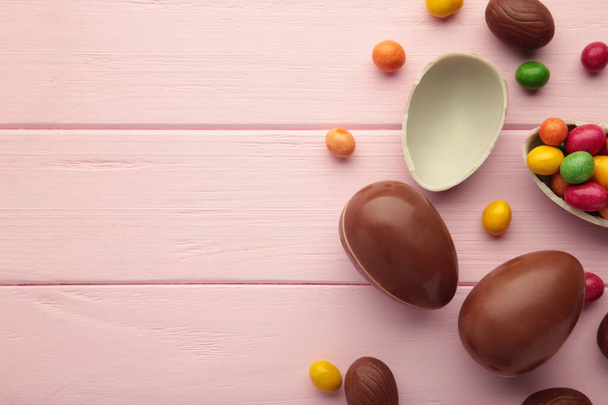 Easter composition with chocolate eggs on pink background, space for text - Valokuva, kuva