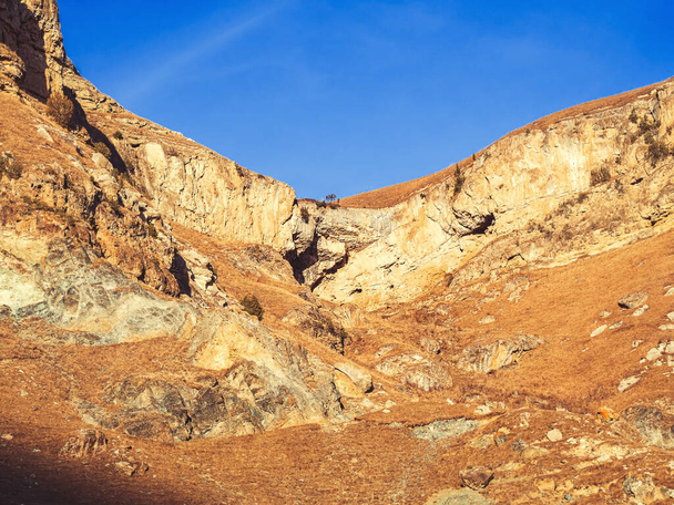 Осеннее скалистое плато, освещенное солнцем против голубого неба. Красота горной местности Кавказа. Долина Нарзанов - Фото, изображение