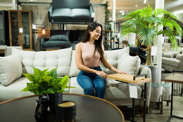 Чудовий жіночий клієнт відчуває себе щасливим, купуючи нові красиві меблі в магазині декору
 - Фото, зображення