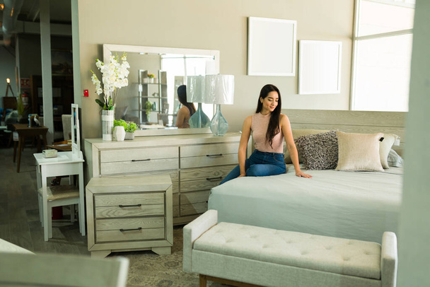 Upea latino nainen tunne onnellinen ostaessaan uusi makuuhuone huonekalut myymälässä - Valokuva, kuva