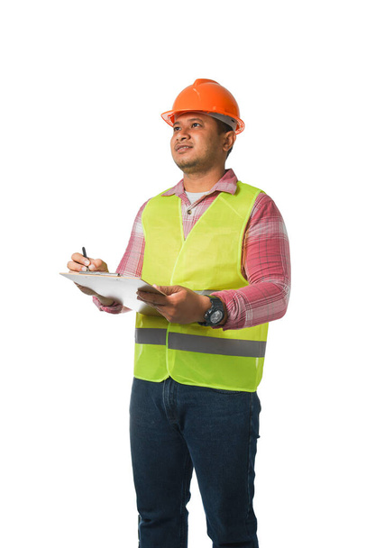 Porträt eines gut aussehenden Chefingenieurs mit hartem Hut. trägt einen reflektierenden Tiger und macht sich Notizen. isoliert auf weißem Hintergrund. - Foto, Bild