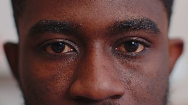 Zbliżenie makro portret piękna młodych afrykańskich mężczyzn oczy, uśmiechnięty model patrząc w aparat - Zdjęcie, obraz