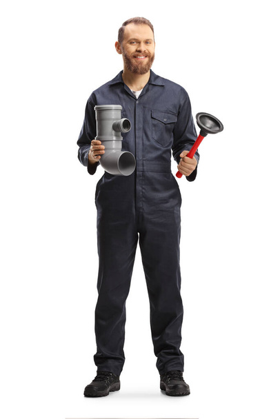 Full length portrait of a plumber holding a plastic pipe and a toilet plunger isolated on white background - Foto, Bild