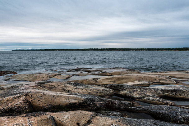 Nuages sombres et roches sauvages sur le littoral de la mer Baltique autour d'Oregrund, Uppland - Suède - Photo, image
