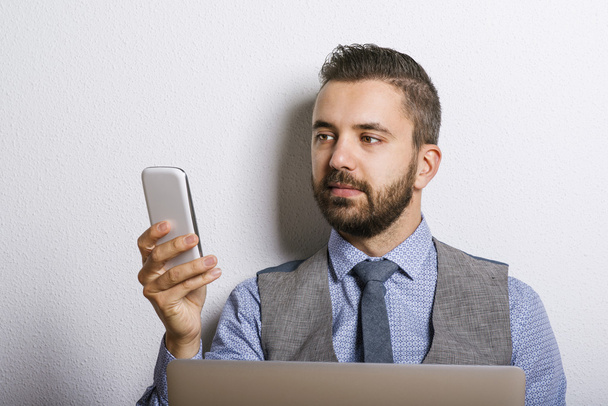 Businessman using smart phone and laptop - Фото, изображение