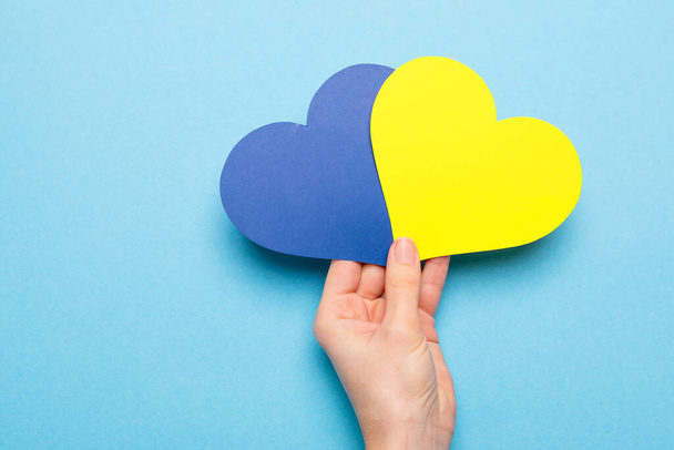 There is no war. blue and yellow heart made of paper in female hands  - Foto, Imagem