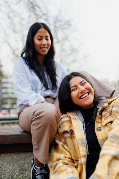 две латинские девочки, сестры, наслаждающиеся днем, весело проводящие время вместе на улице.. - Фото, изображение