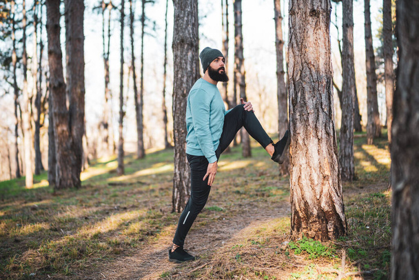 Man with beard enjoys exercising in nature. - Zdjęcie, obraz