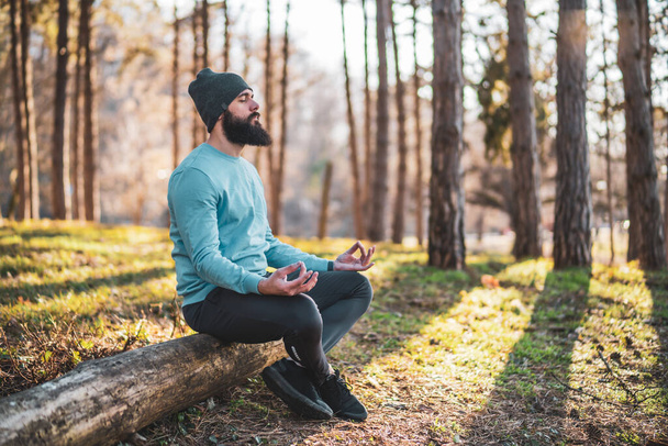 Sporty man enjoys meditating in the nature. - Foto, Imagen