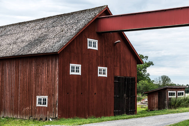 Draknas, Uppland - Švédsko - 07 29 2019 Pohled na švédskou krajinu s venkovským zázemím a červenými dřevěnými statky v tradičním stylu - Fotografie, Obrázek