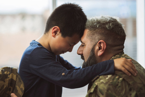 Στρατιώτης καλωσορίζει το γιο του στο σπίτι - οικογενειακές ιδέες στον πόλεμο - - Φωτογραφία, εικόνα