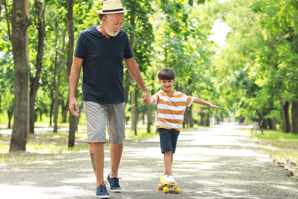 Hombre mayor y su nieto patinando en el parque - Foto, Imagen