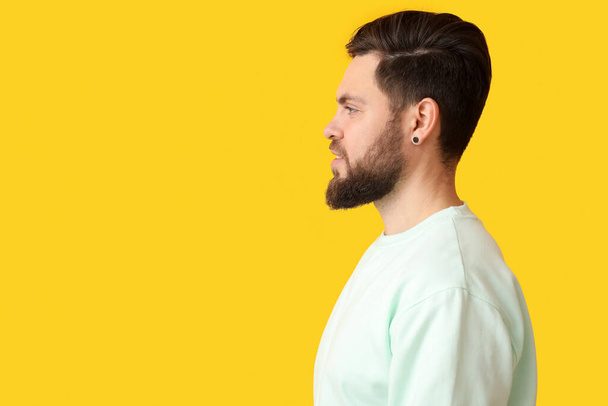 Stylish bearded man on yellow background - Photo, Image