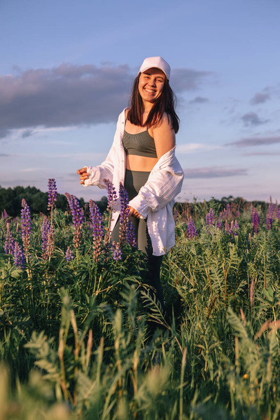 donna felice nel centro del campo con fiori Lupinus copiare spazio - Foto, immagini