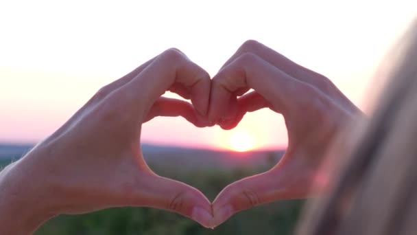 Mostrar gestos de la mano corazón sobre fondo rosa atardecer, amor y concepto de salud - Metraje, vídeo