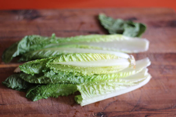 Gemüse, das zum Zerkleinern vorbereitet wird, liegt mit einem Messer auf einem Holzschneidebrett. - Foto, Bild