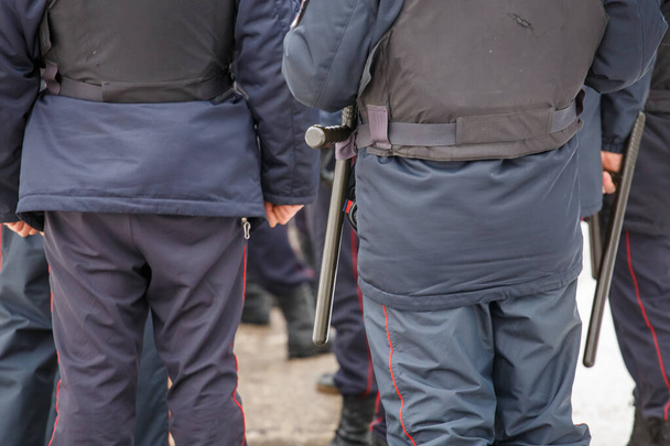 russian police officer with black rubber tonfa baton hanging on his belt - Foto, Bild