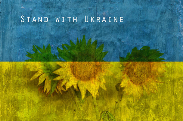 ウクライナの国旗と碑文と古い青の黄色のグランジの壁の背景"ウクライナと立つ" - 写真・画像
