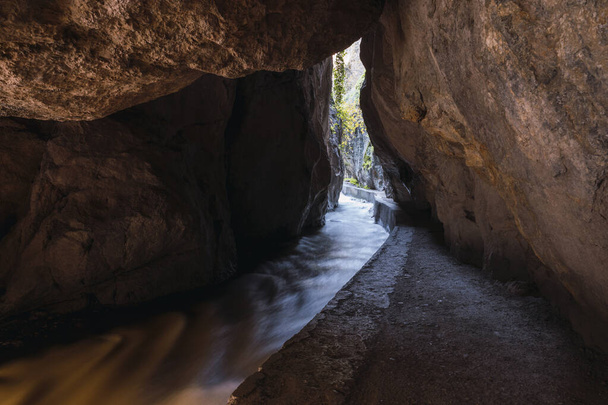 Entrada estrecha a la cueva entre montañas en la ruta del río Monachil, en Los Cahorros, Granada, España. - Foto, imagen
