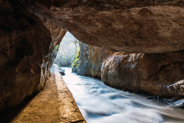 Exit from the cave between mountains on the route of the Monachil river, in Los Cahorros, Granada, Spain. - 写真・画像
