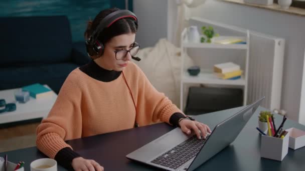 Nuori nainen osallistuu videopuhelu kokous kannettavan tietokoneen kuulokkeet - Materiaali, video