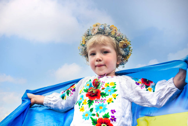 zászló Ukrajna kezében boldog lány ukrán. gyerek mosolyog visel ukrán zászló kék és sárga zászló Ukrajna lengő kék ég háttér. Függetlenség Napja. Zászlónap. Alkotmány napja - Fotó, kép