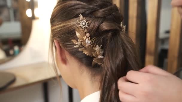 Professionelle Friseurin kräuselt einem Kunden die Haare, während sie ihre Hochzeitsfrisur im Schönheitssalon macht. - Filmmaterial, Video