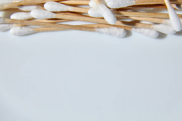 フラットレイ環境に優しい綿棒、竹の綿の芽、白い背景に耳をきれいにするための木製の棒、コピースペース. - 写真・画像