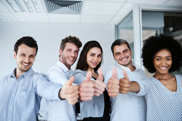 Odvádíš skvělou práci. Portrét skupiny podnikatelů ukazující palce nahoru v kanceláři. - Fotografie, Obrázek