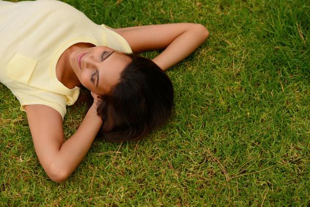 Mohl bych tu ležet celý den. Vysoký úhel záběru mladé ženy ležící na trávě. - Fotografie, Obrázek