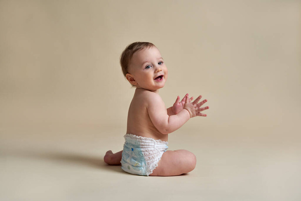 Petit bébé caucasien assis sur fond nu  - Photo, image
