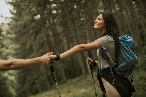 Coppia di giovani escursionisti con zaini passeggia nel bosco - Foto, immagini
