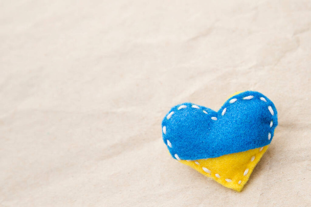 Ukraine flag theme. Heart shape pin badge made of blue and yellow stuffed felt. Topical issues of war. Freedom fighters. Support of nations, unity. Pray for peace. No war. - Photo, Image