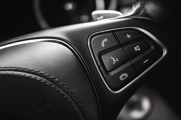 Botón de control del volante en el interior del coche de lujo con interior de cuero. Fondo del vehículo moderno  - Foto, imagen