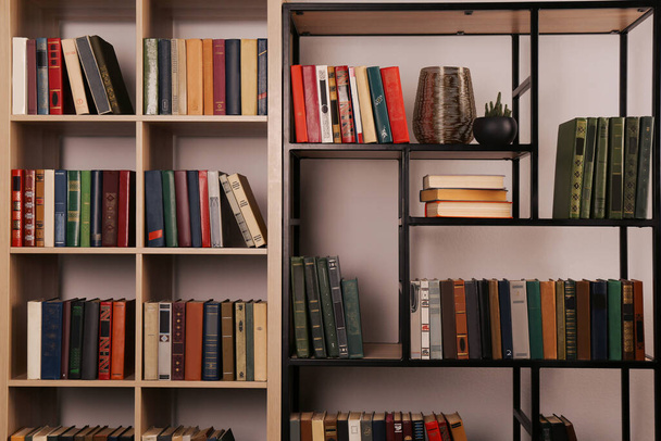Collection of different books on shelves in home library - Fotó, kép