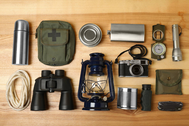 Set of traveler's equipment on wooden table, flat lay - Foto, afbeelding