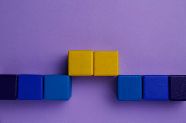 Bridge made of colorful blocks on violet background, flat lay. Connection, relationships and deal concept - 写真・画像