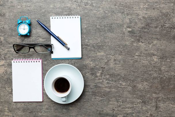 Tavolo da ufficio moderno con notebook e altre forniture con tazza di caffè. Pagina bianca del taccuino per voi progettazione. Vista dall'alto, piatta. - Foto, immagini