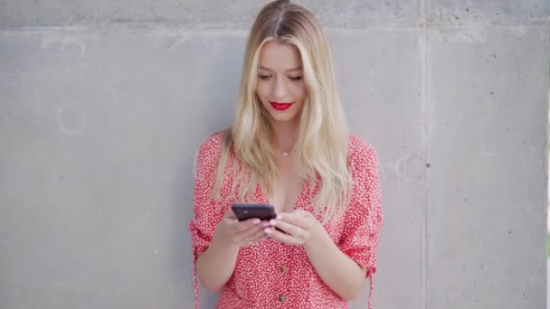 Iloinen nuori nainen käyttää älypuhelinta - Materiaali, video