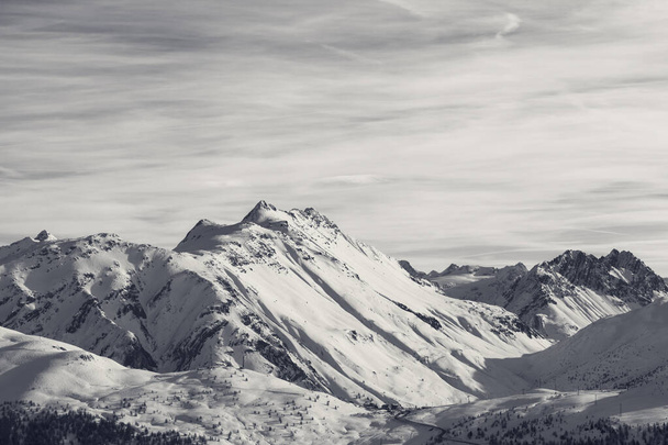 Snowy high winter mountains and beautiful cloudy sunlit sky. Italian Alps. Livigno, region of Lombardy, Italy, Europe. Black and white retro toned landscape. - Fotoğraf, Görsel