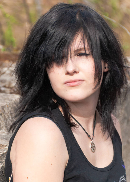 Punk emo lány, fiatal felnőtt, fekete haj és szemceruza, közelről, néz félre, álló, szabadban, vetical - Fotó, kép