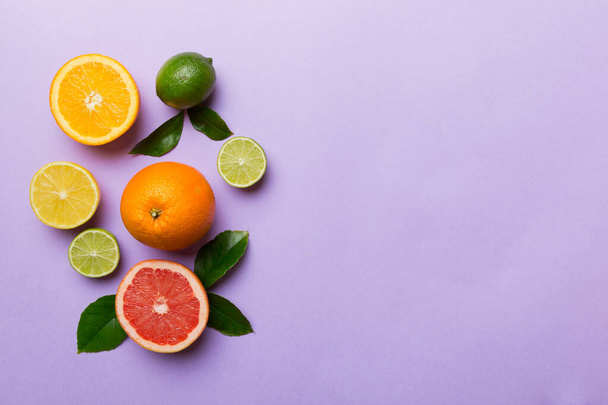Fruit background. Colorful fresh fruits on colored table. Orange, lemon, grapefruit Space for text healthy concept. Flat lay, top view, copy space. - Photo, Image
