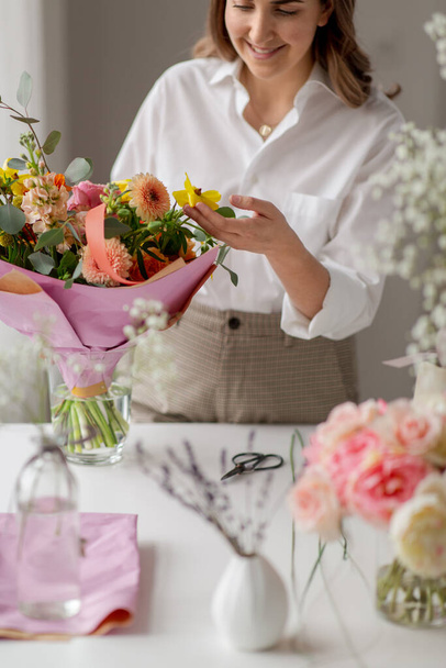 happy woman or floral artist with flowers at home - 写真・画像