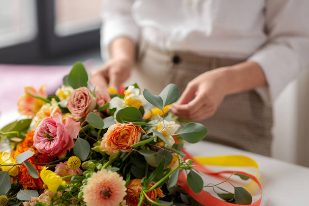 close up of woman making bunch of flowers on table - 写真・画像