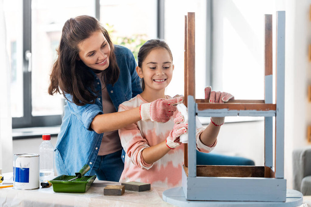 mother and daughter cleaning old wooden table - Photo, image