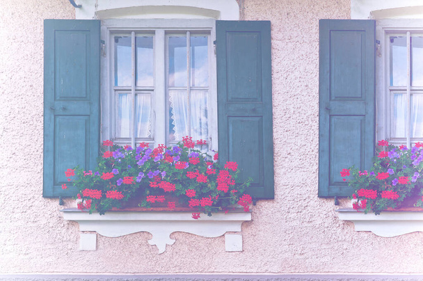 Ventanas cerradas bávaras decoradas con geranios, tradicionales para el sur de Alemania, en efecto de color desvanecido. - Foto, Imagen