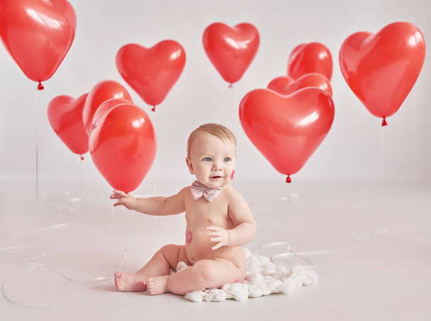 Valentine Baby boy with kiss on cheek. Valentine's Day. Balls and flowers. Celebration. Mother's day postcard. International day of happiness. Birthday party. - Fotoğraf, Görsel