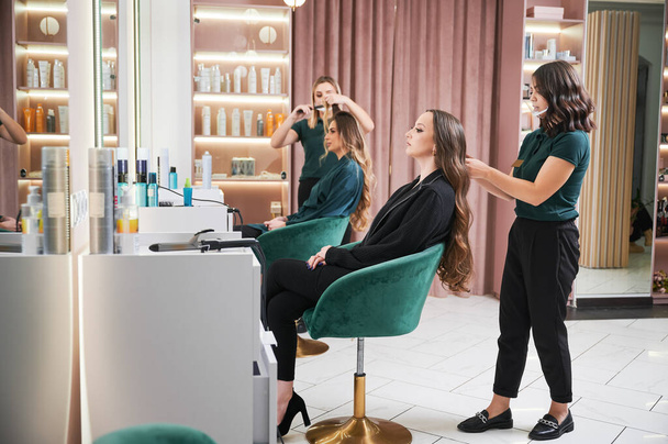 Парикмахер кёрлинг женские волосы в салоне красоты. - Фото, изображение