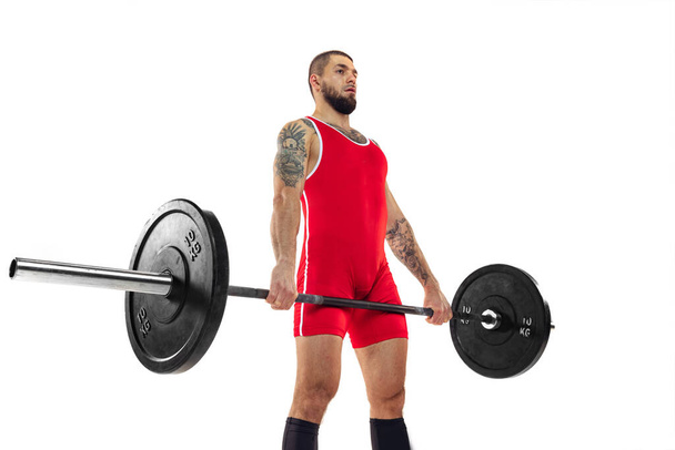 Close-up strong man red sportswear raising barbell up isolated on white background. Sport, weightlifting, power, achievements concept - Foto, Bild