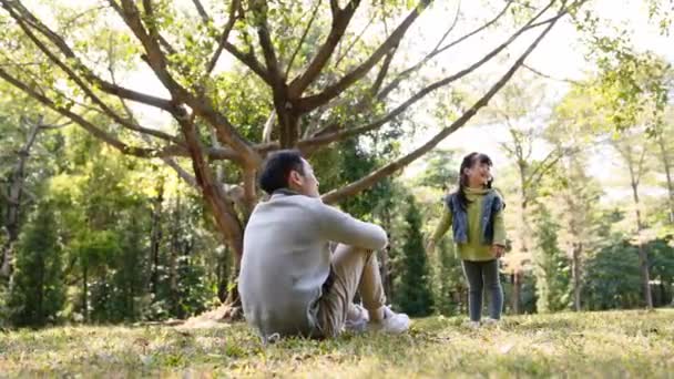 nuori aasialainen isä, jolla on hyvä aika tyttären kanssa ulkona puistossa - Materiaali, video